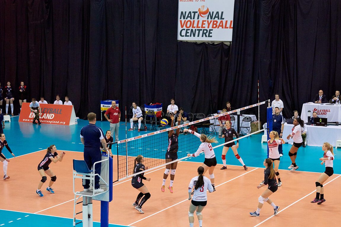 una imagen que muestre un equipo de voley con jugadores en la cancha y suplentes en el banquillo